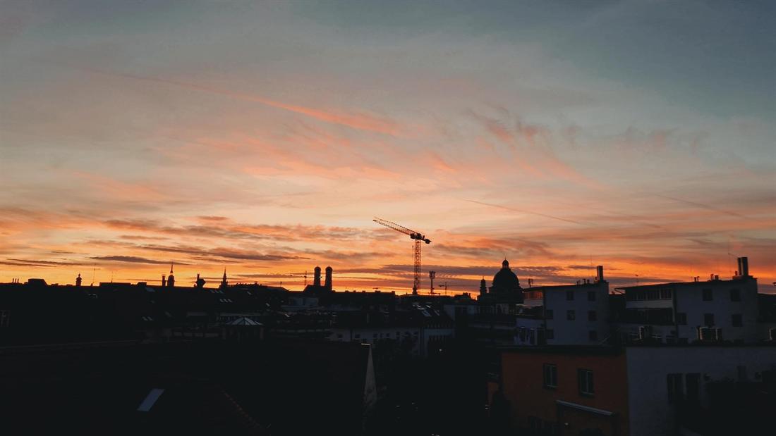 Abendhimmel über den Dächern von München, fotografiert vom MDS-Büro in Lehel, mit der Silhouette der Frauenkirche